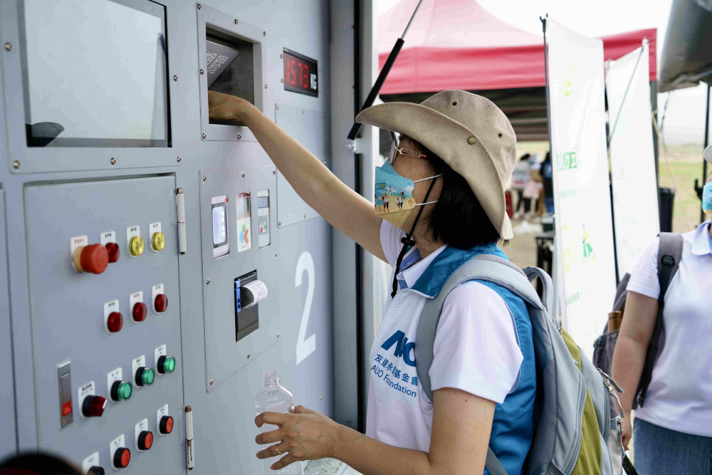 志工們將拾起的寶特瓶投入「好歸塑專車」，讓廢棄塑料空瓶可以直接粉碎、縮小體積，未來將可再製成購物袋、寶特衣、悠遊卡等生活用品